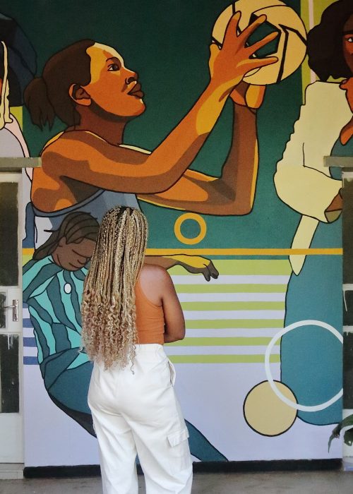 Lerato looks at the Mural she designed. The mural consists of illustrations of 4 women: Professor Address Malata, Joyce Mvula, Rachel Sibande and Tabitha Chawinga